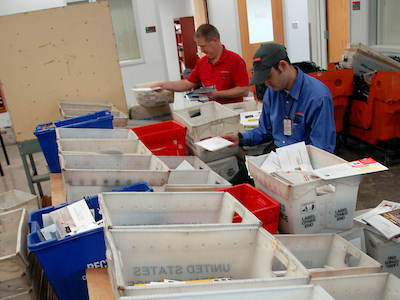 University Mail clerks flip letter sinto the correct bin while sorting mail. PHOTO BY ROGER WINSTEAD