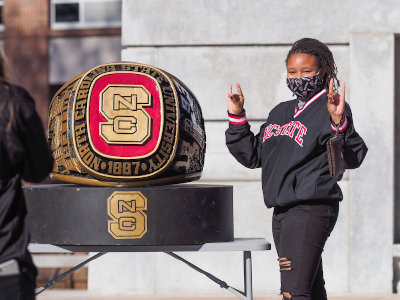 Students pose by a large class ring at the NC State belltower during the ring ceremony at the end of the semester. Photo by Marc Hall